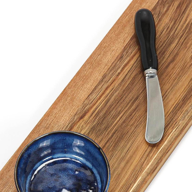 O planșă pentru servirea gustărilor, cu un vas și un cuțit