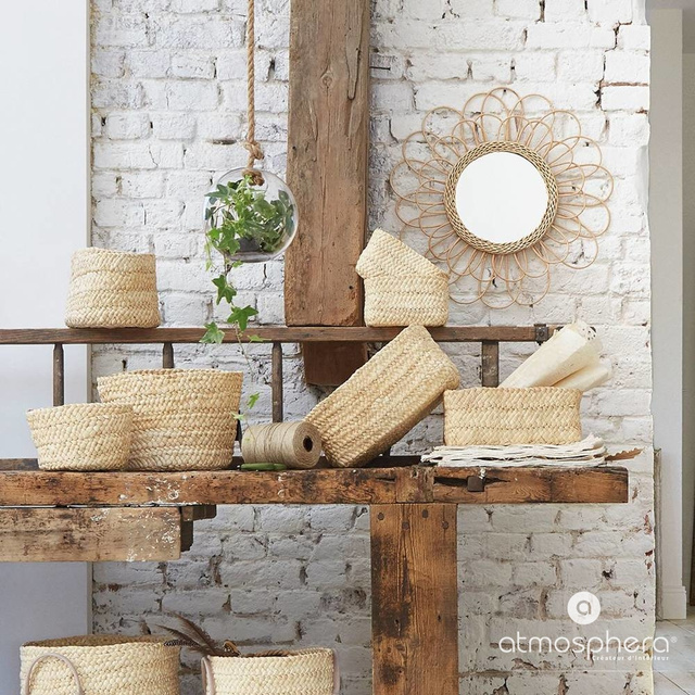 O oglindă într-un cadru țesut, din răchită cu o formă interesantă pentru camera de zi sau dormitor